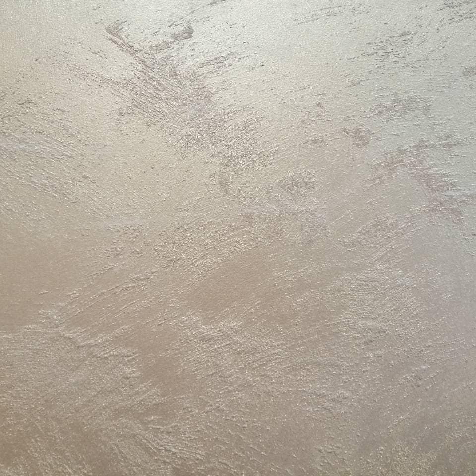 Close view of Swahili Effect plaster: fine trowel strokes and a soft pearl sheen across a warm taupe surface.
